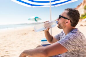 mężczyzna na plaży pod parasolem